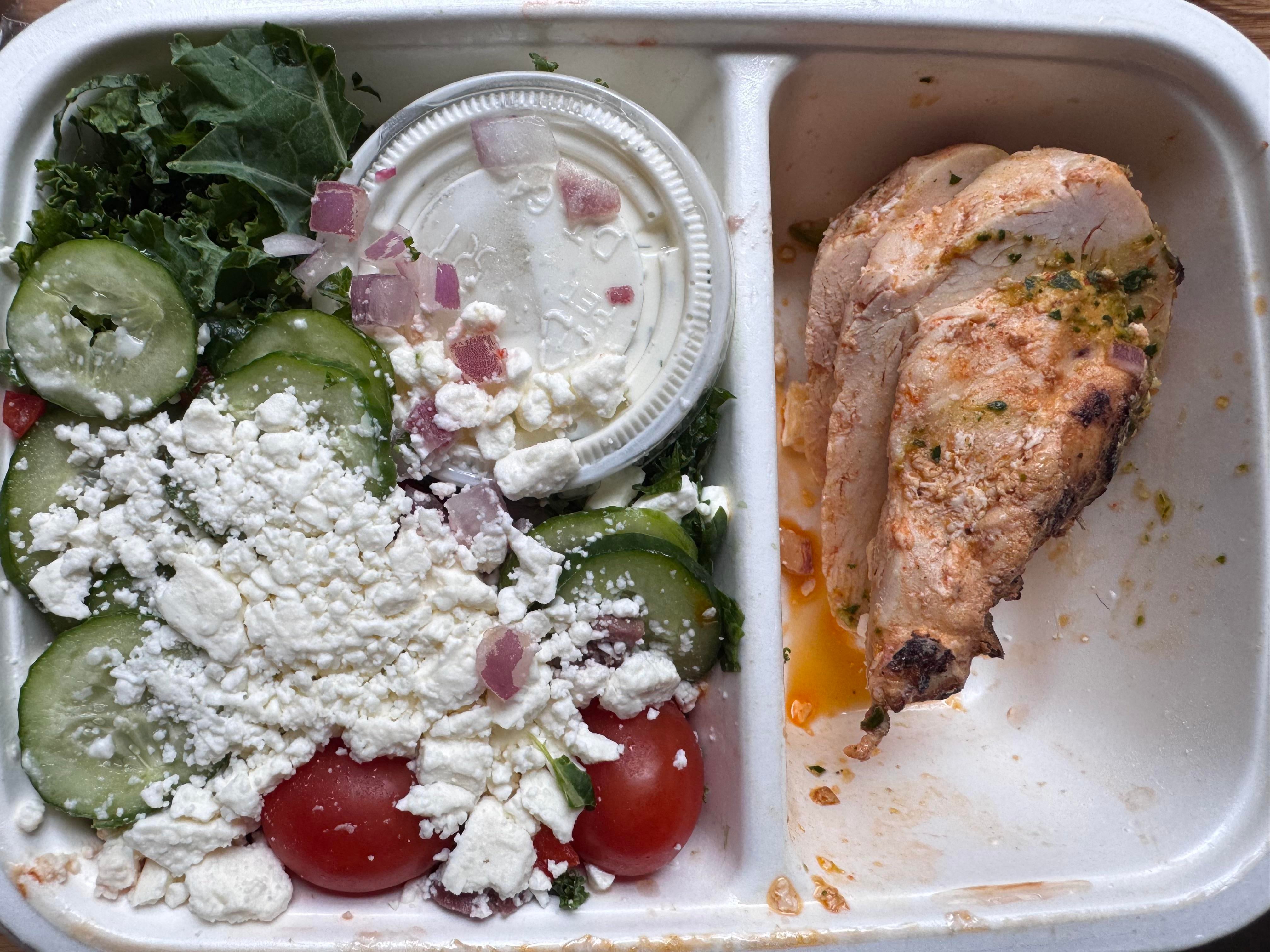 CookUnity Greek style chicken power bowl with feta, cucumber and tomatoes beside grilled chicken