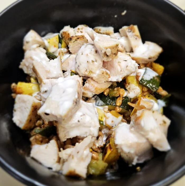 Blue Apron chicken with goat cheese sauce over farro with roasted squash and zucchini in a black bowl
