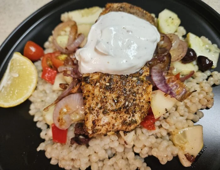 Blue Apron crispy skin salmon over pearl couscous with labneh, tomatoes, red onion, olives and a lemon wedge