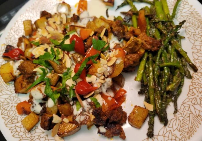 Blue Apron pork chorizo, potato and fig bake with almonds, tomatoes and lemon mayo beside roasted asparagus on a floral plate