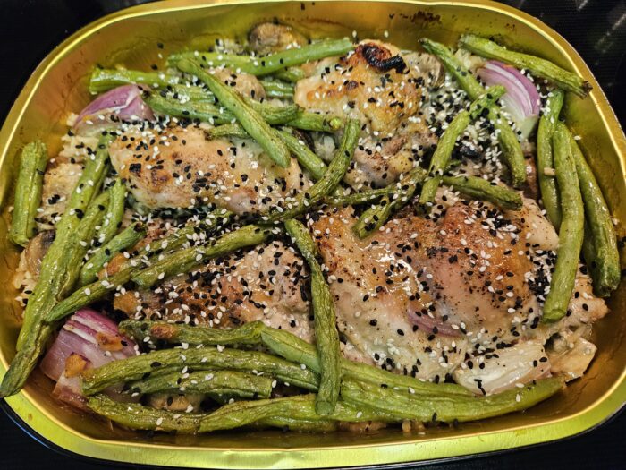 Blue Apron oven baked miso maple chicken thighs over rice with green beans, red onion and sesame seeds in a foil tray