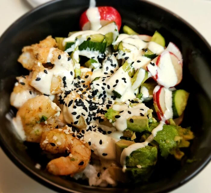 Blue Apron shrimp and sushi rice bowl with avocado, cucumber, radish, yuzu mayo and black sesame in a black bowl