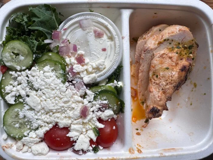 CookUnity Greek style chicken power bowl with feta, cucumber and tomatoes beside grilled chicken
