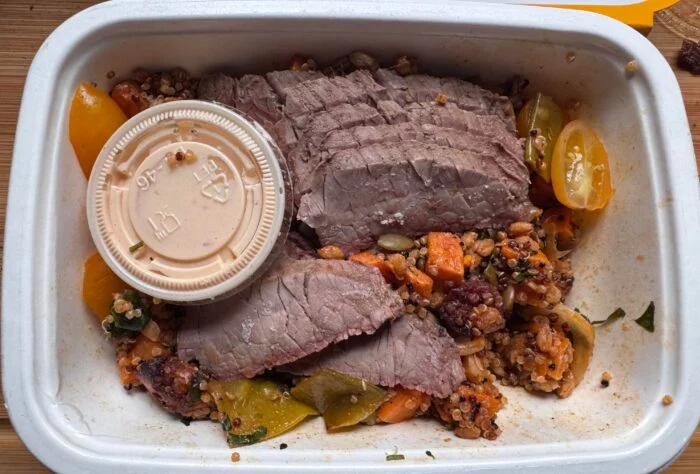 CookUnity sliced flank steak on a quinoa grain bowl with sweet potato and tomatoes