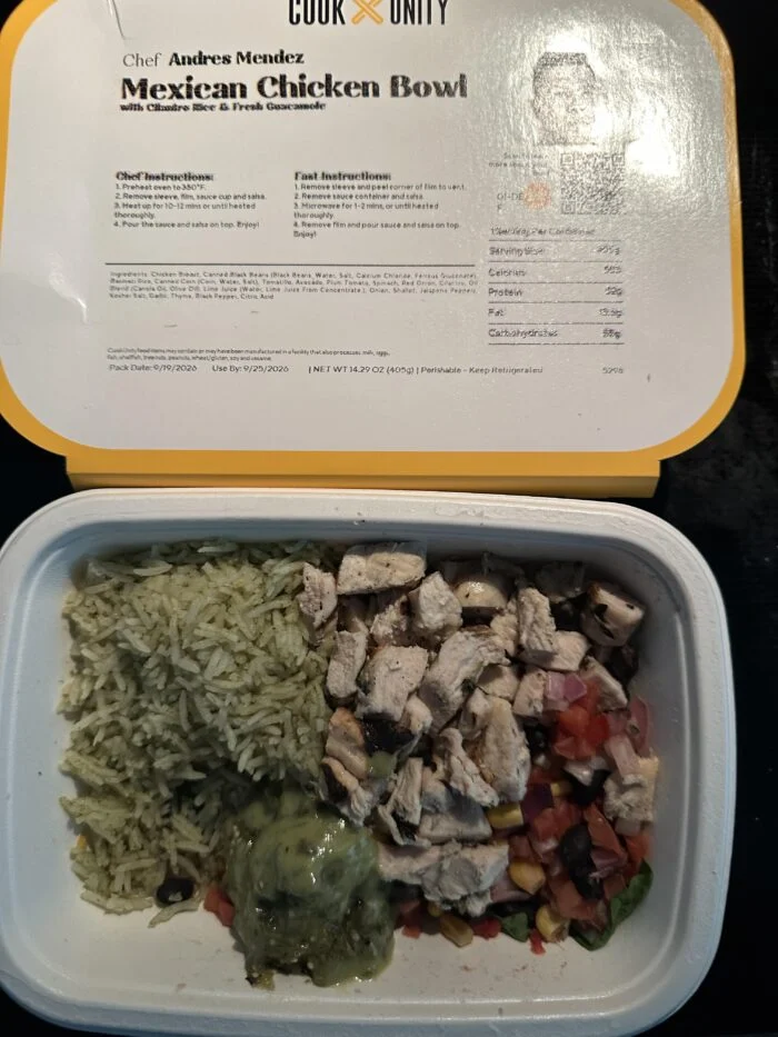 CookUnity Mexican chicken bowl, diced chicken with green cilantro rice, bean and corn salsa and guacamole, chef label open behind the tray