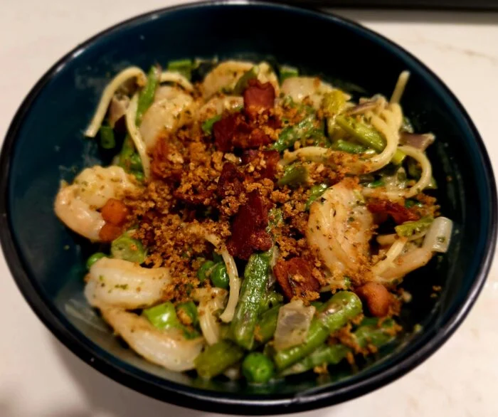 Green Chef creamy shrimp spaghetti primavera with bacon, green beans, peas and toasted breadcrumbs in a dark bowl