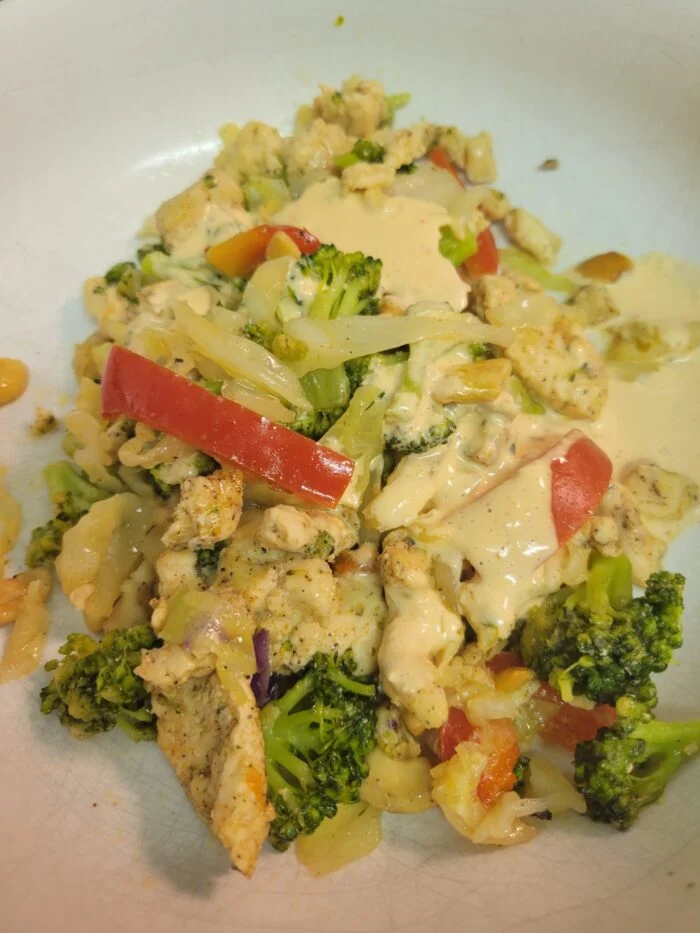 Green Chef spicy chicken and broccoli stir fry with red bell pepper, cashews and creamy aioli on a white plate