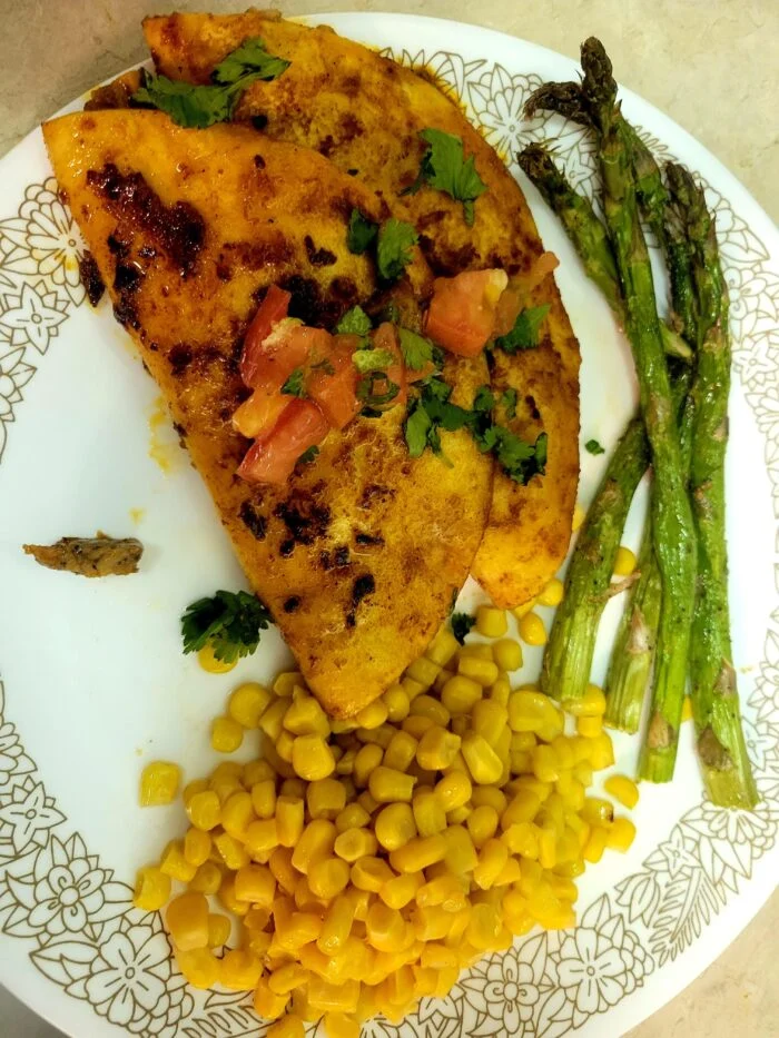 HelloFresh birria style pork tacos with pico de gallo and cilantro, corn and roasted asparagus on a plate