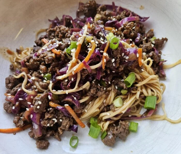 HelloFresh bulgogi beef noodle stir fry with red cabbage, carrots, scallions and sesame seeds in a bowl