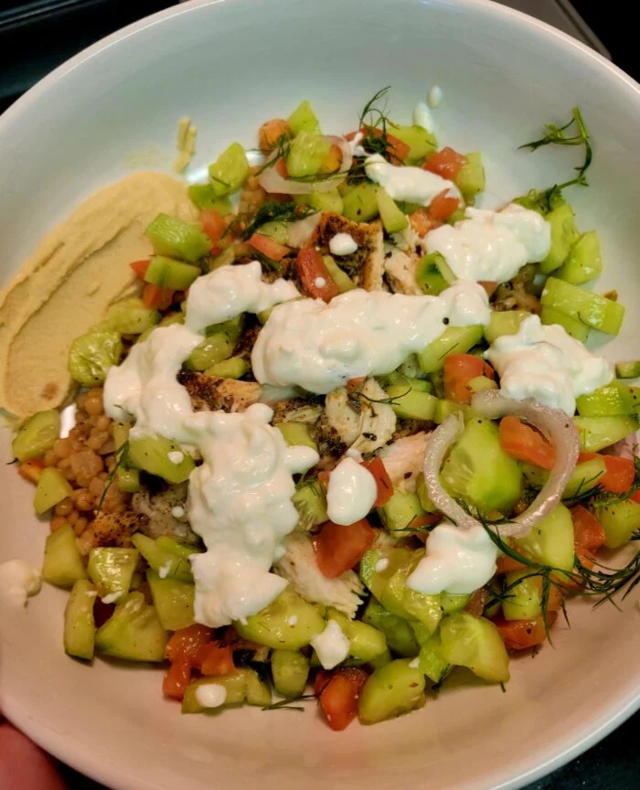 HelloFresh chicken gyro couscous bowl with hummus, cucumber tomato salad, feta sauce, red onion and dill