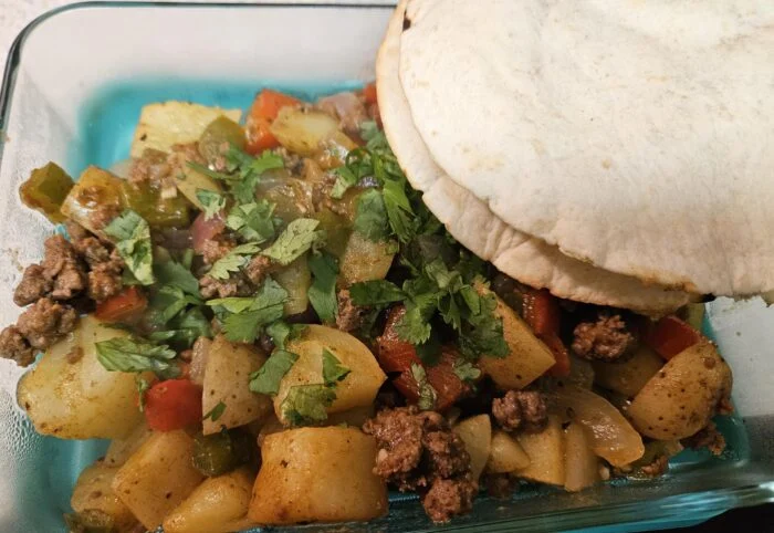 HelloFresh Costa Rican style beef picadillo de papa with potatoes, peppers, cilantro and tortillas in a glass dish