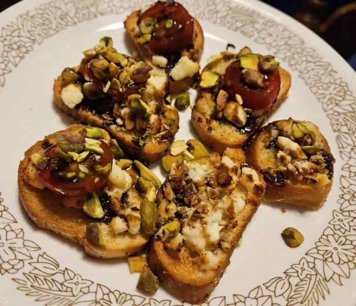 HelloFresh feta, balsamic and pistachio crostini with tomato slices on toasted bread on a patterned plate