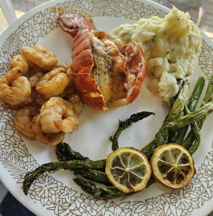 HelloFresh garlic butter shrimp and lobster tail with roasted asparagus, charred lemon slices and mashed potatoes on a plate