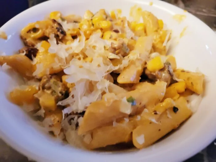 HelloFresh Mexican street corn pasta with penne, corn kernels and grated cheese in a white bowl