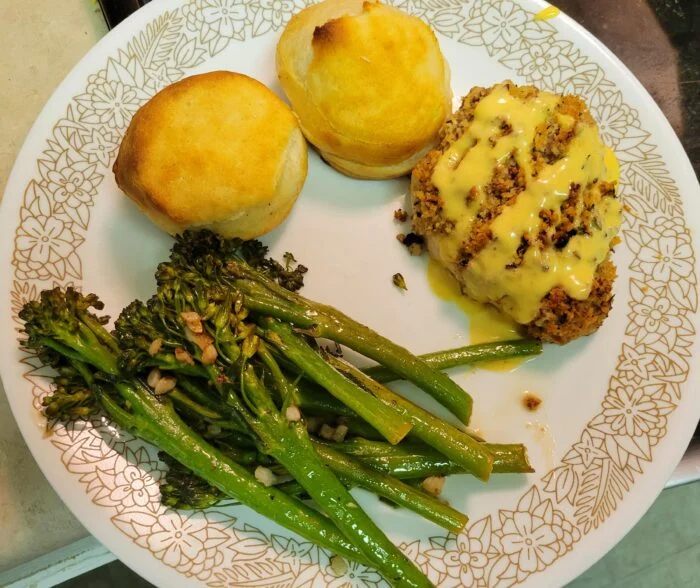 HelloFresh pecan chicken royale with sauce, two garlic thyme biscuits and garlic broccolini on a plate