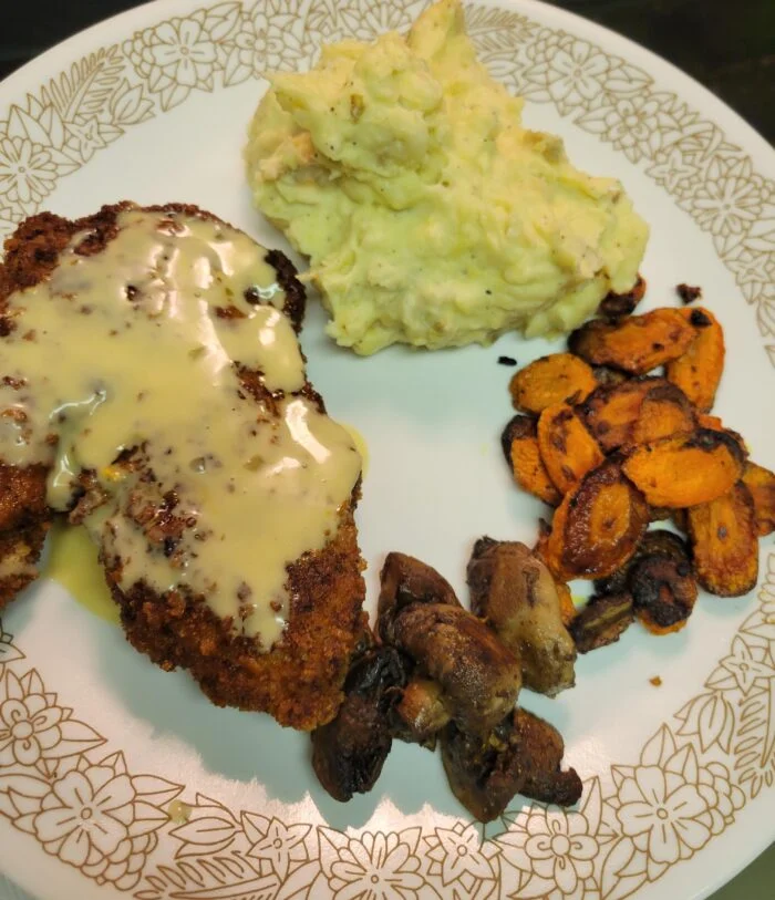 HelloFresh pork schnitzel with creamy dijon sauce, mashed potatoes, roasted carrots and mushrooms on a floral plate