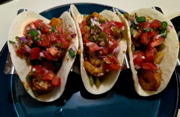 HelloFresh southwest shrimp tacos with pico de gallo, jalapenos and spicy crema, three tacos on a teal plate