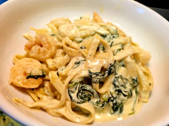 Home Chef Florentine shrimp Alfredo with fettuccine, shrimp and spinach in cream sauce in a white bowl