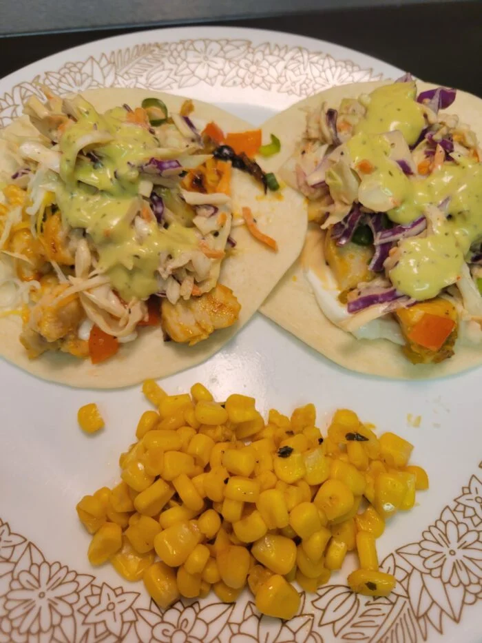 Home Chef sweet and sour mango chicken tacos with slaw and green sauce on flour tortillas, side of corn on a plate