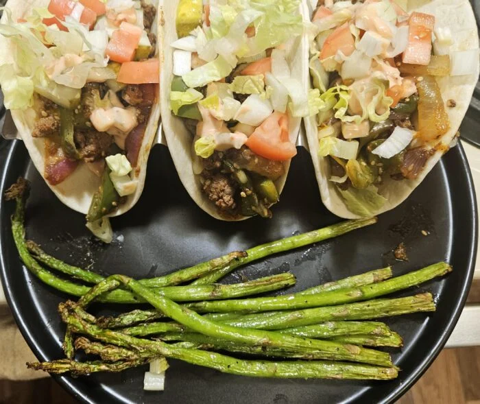 Marley Spoon cheeseburger tacos with ground beef, lettuce, tomato, special sauce and pickles, roasted asparagus