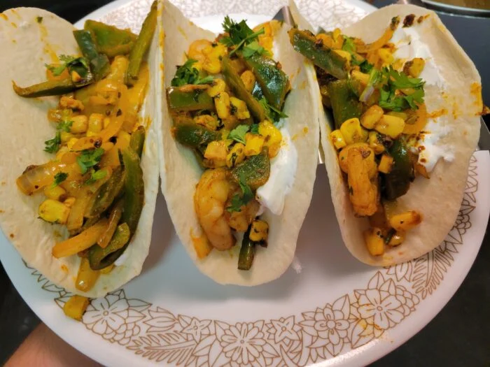 Marley Spoon shrimp fajitas in flour tortillas with corn, poblano peppers, onions, sour cream and cilantro on a floral plate