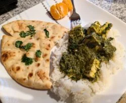 HelloFresh palak paneer, dark green spinach curry with paneer cubes, served with white rice and a folded naan