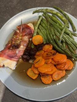 HelloFresh prosciutto wrapped chicken in a dark cherry sauce with glazed carrot coins and green beans
