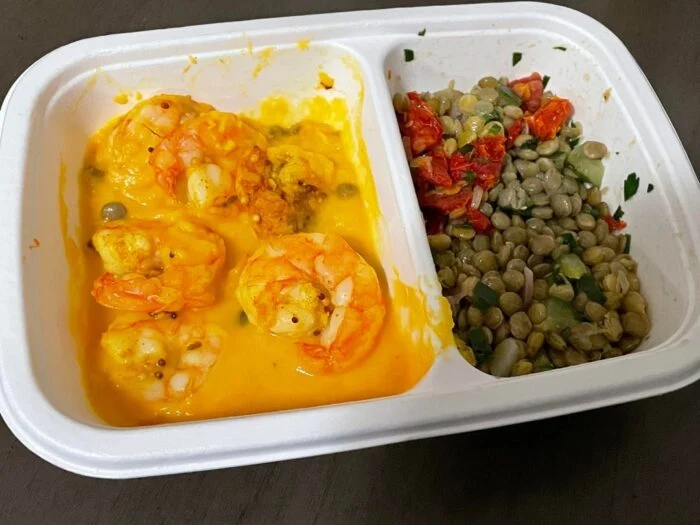 CookUnity curry shrimp in squash puree with lentils in its divided tray.