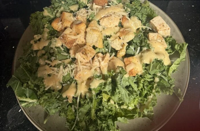 CookUnity grilled chicken kale Caesar with croutons and Parmesan, plated by a reader.