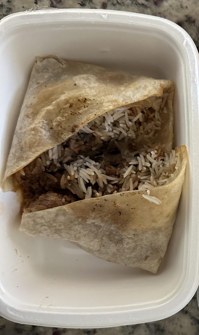 Reader photo of a CookUnity Mission Style beef and rice burrito cut in half in its delivery tray