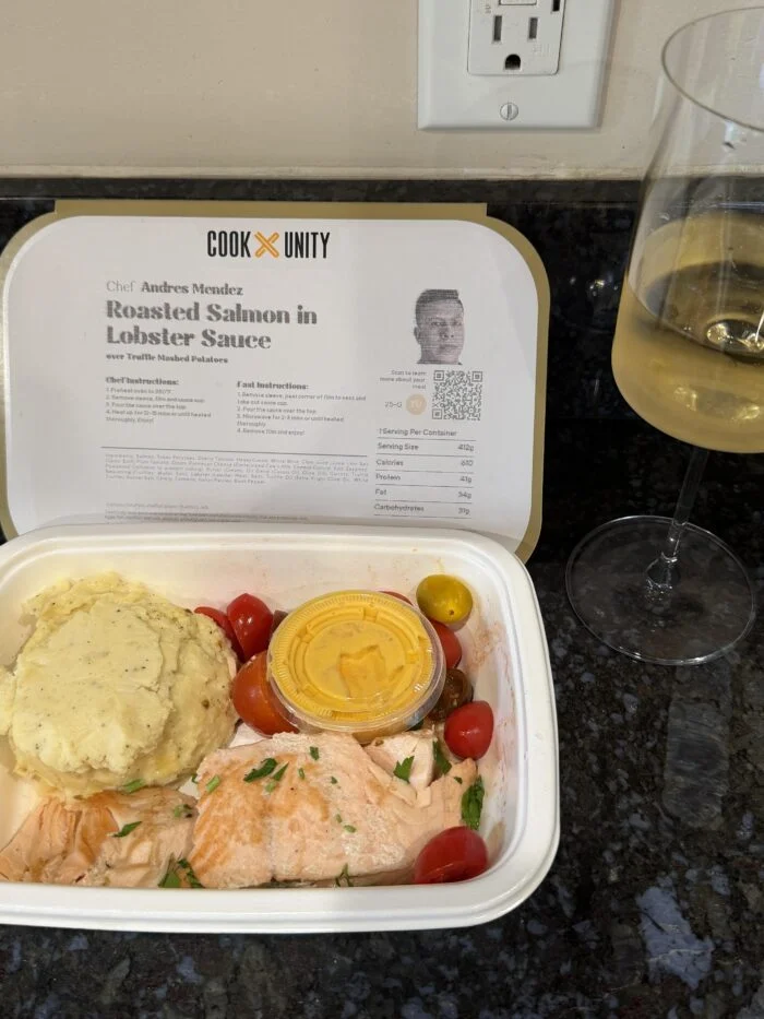 CookUnity roasted salmon with lobster sauce, mashed potatoes and tomatoes in the tray, chef label behind