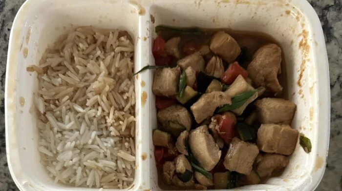 Reader photo of CookUnity Sichuan kung pao chicken with peppers beside basmati rice in its delivery tray