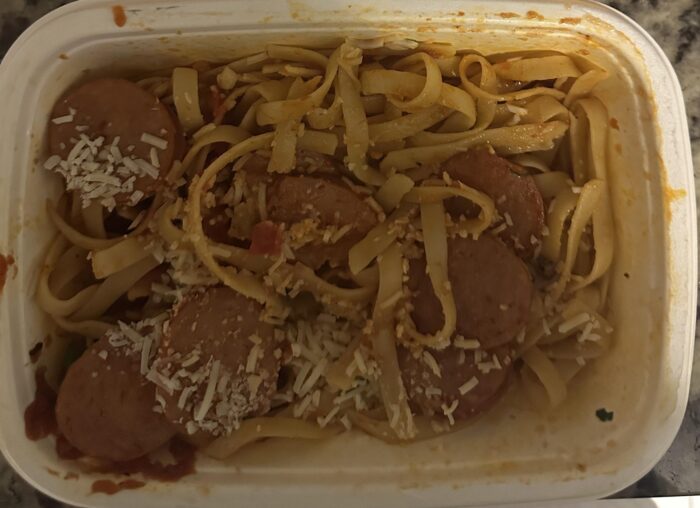 CookUnity fettuccine in red sauce with sliced sausage and shredded Parmesan