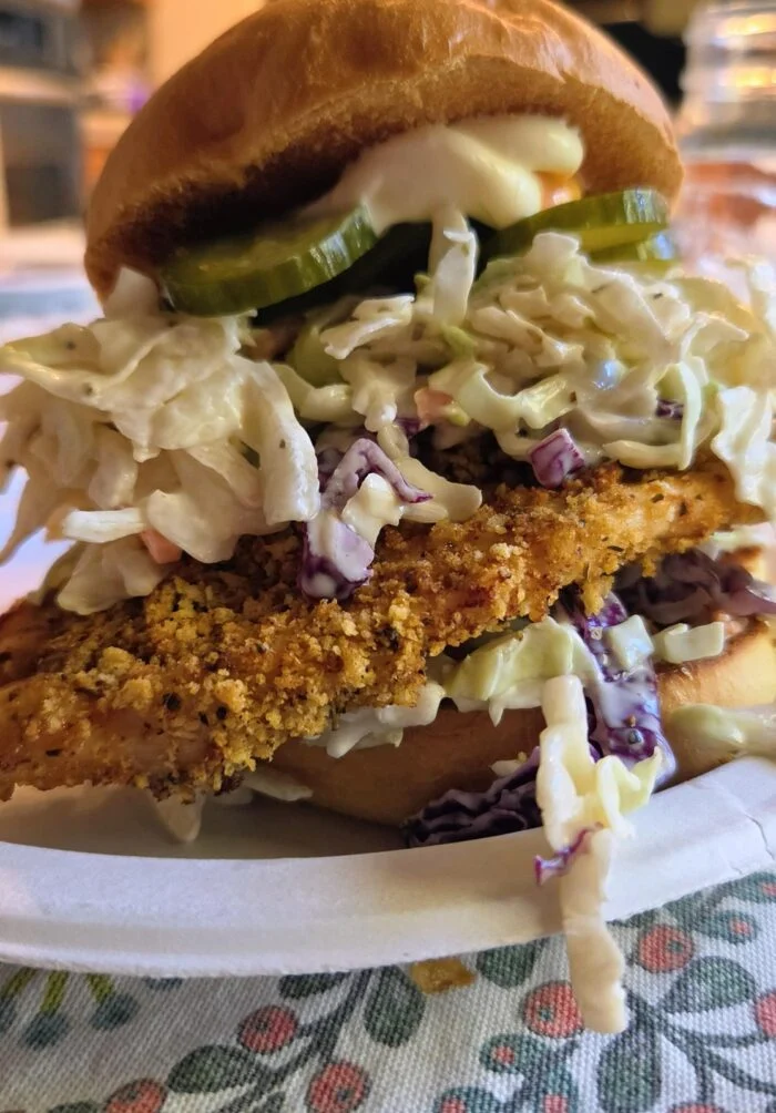 HelloFresh Cajun air fryer chicken sandwich with coleslaw on a brioche bun.
