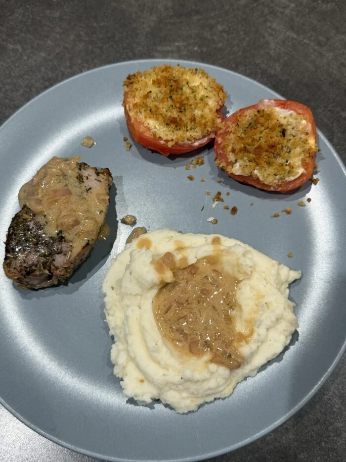 Reader-prepared HelloFresh roasted pork filet, cheese-stuffed tomatoes and mashed potatoes. The reader omitted parsley, added shallot to the tomatoes and used their own sour cream in the sauce.