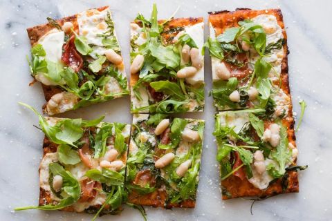 Prosciutto flatbread pizzas with mozzarella, white beans, and arugula